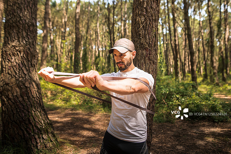 男人在森林里用橡皮筋锻炼图片素材