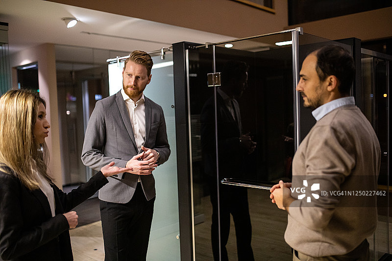 年轻情侣在玻璃店与售货员交谈图片素材