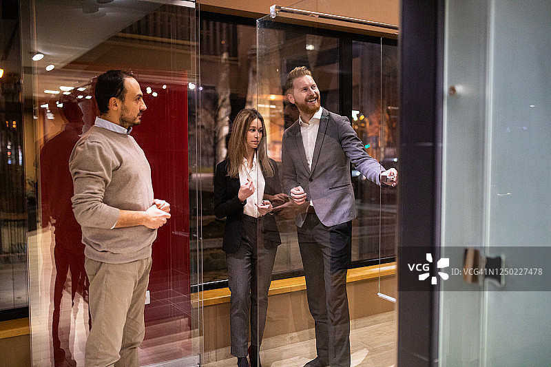 年轻情侣在玻璃店与售货员交谈图片素材