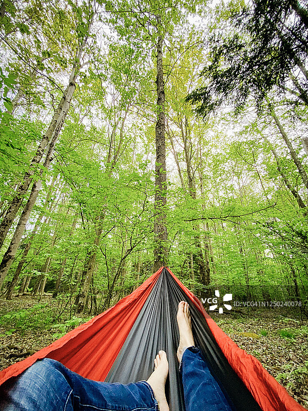 在森林中露营，吊床上双脚的POV视角图片素材