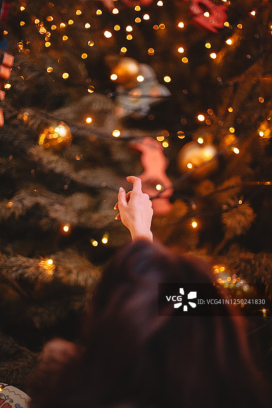 对着圣诞树许愿的少女背影图片素材