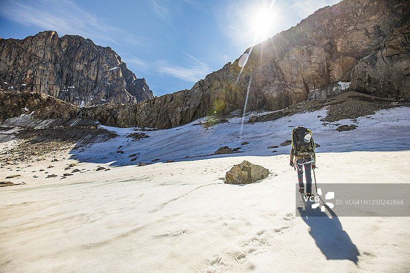 背包客接近岩石峭壁的后视图图片素材