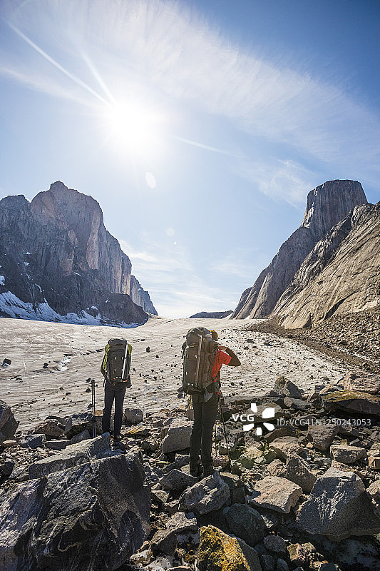 两名背包客在巴芬岛阿克夏亚克山口欣赏风景图片素材