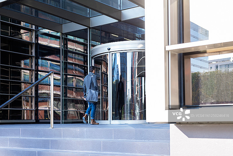 年轻的行政人员走进办公楼图片素材