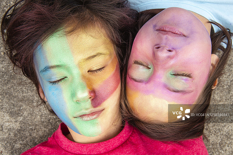 两个画着脸谱的儿童平静地闭着眼睛躺在一起图片素材