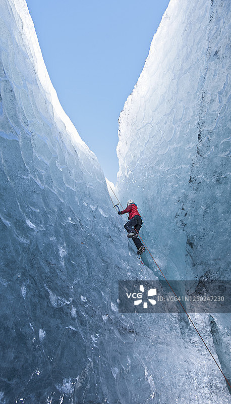 冰岛冰川洞穴中攀爬的女人图片素材