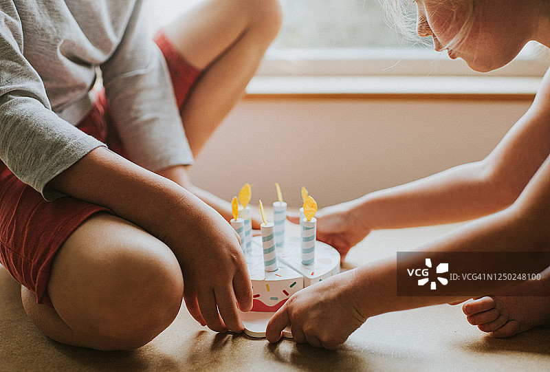 男孩和女孩玩木制生日蛋糕图片素材