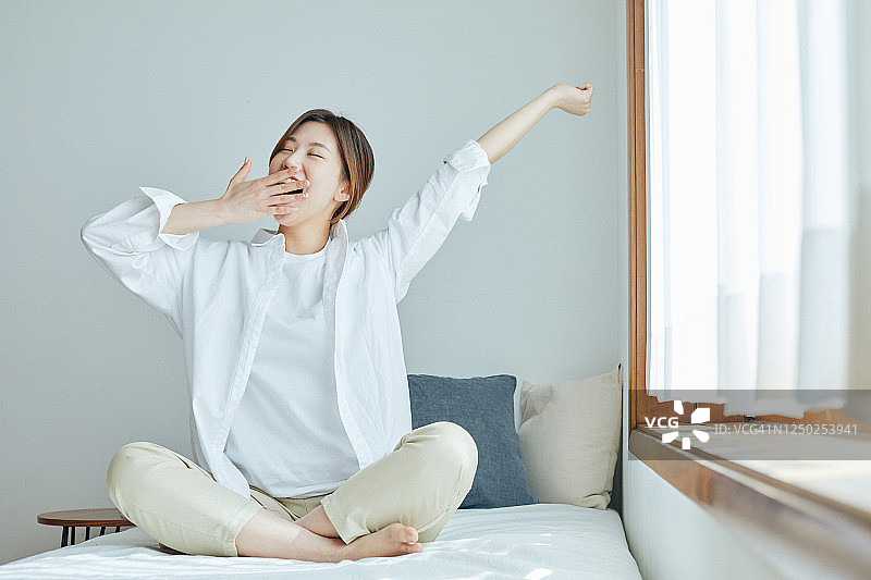 在床上伸展双臂的女人图片素材