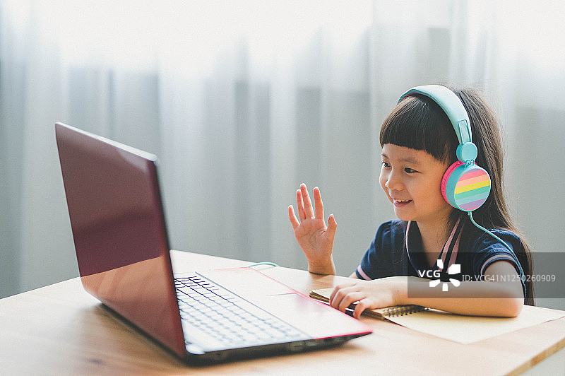 疫情期间在家用笔记本电脑学习的年轻亚洲女孩图片素材