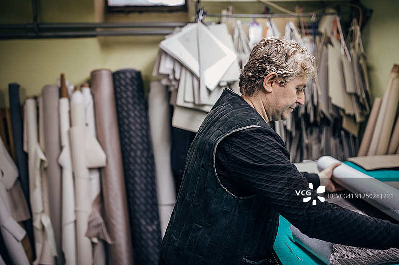 在纺织车间独自工作的年长的男人图片素材