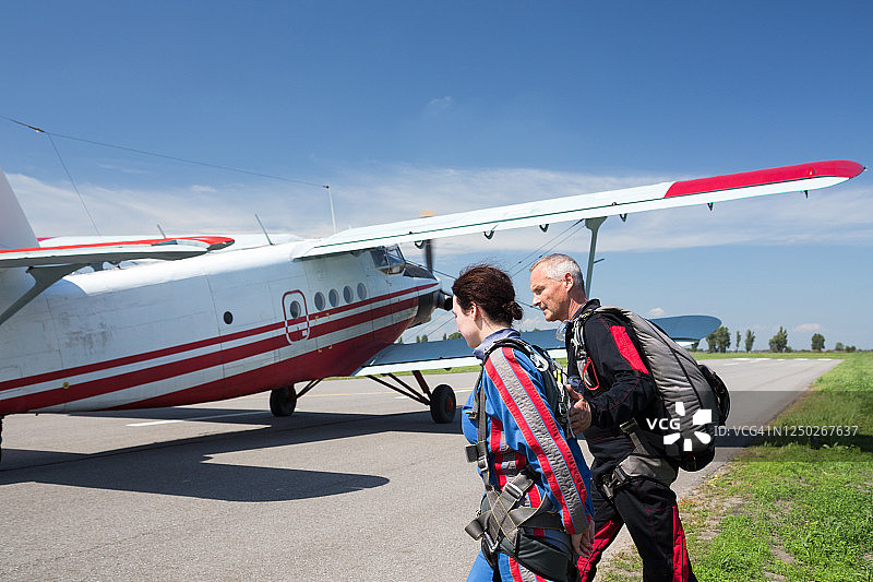 女人和跳伞教练走向飞机图片素材