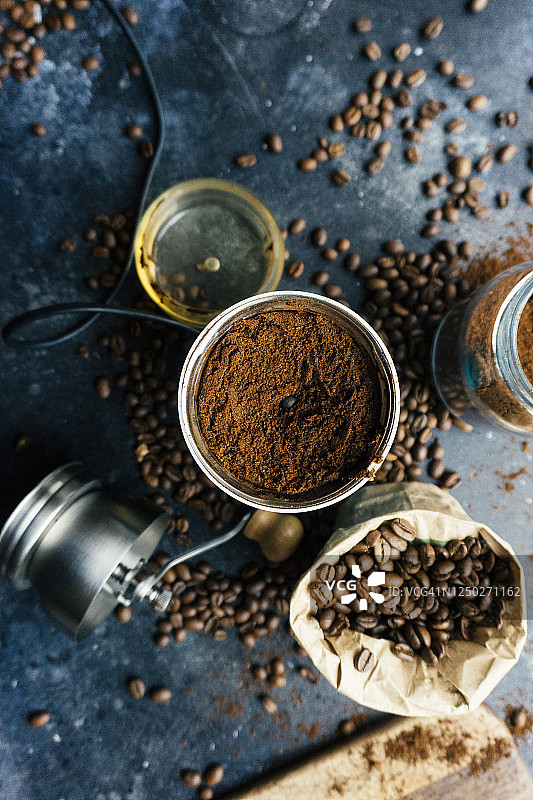 深色背景上的老式咖啡研磨机中的咖啡豆。研磨咖啡和咖啡豆图片素材