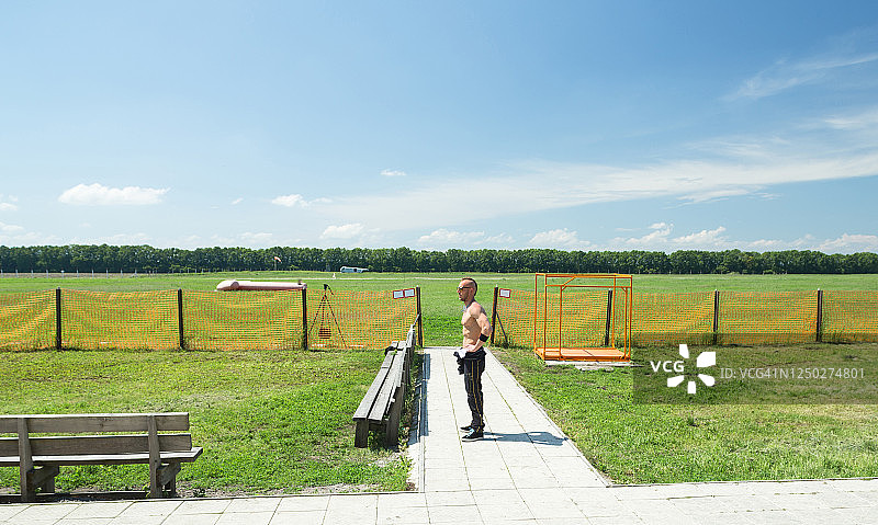 年轻跳伞员站在机场附近图片素材