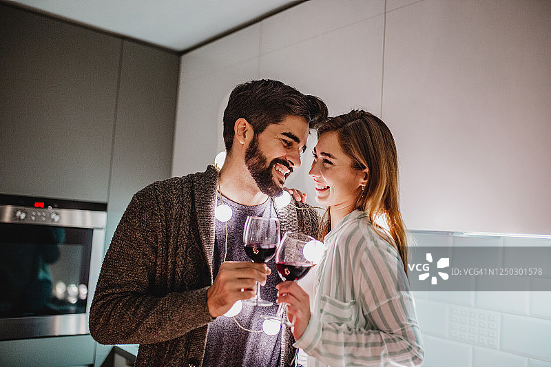 年轻情侣在家喝葡萄酒图片素材