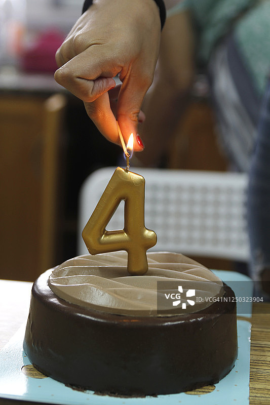 用火柴点燃4根生日蜡烛的手图片素材