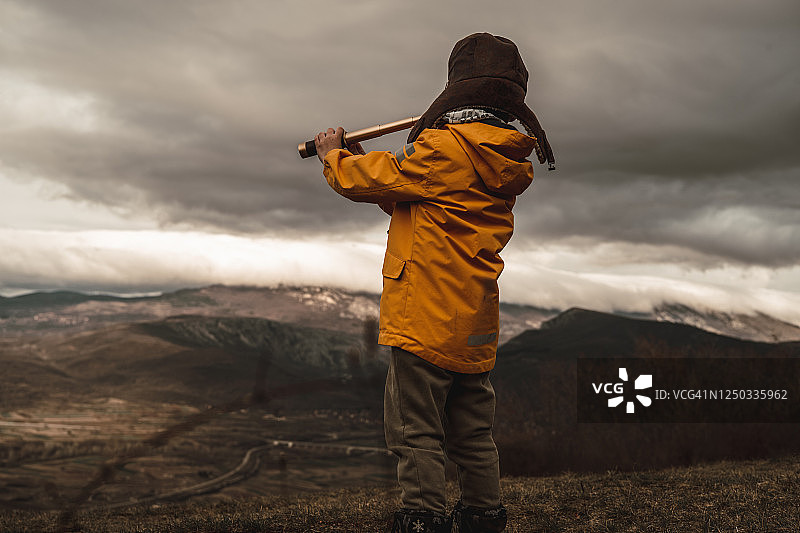 在自然中用双筒望远镜观察的男孩图片素材