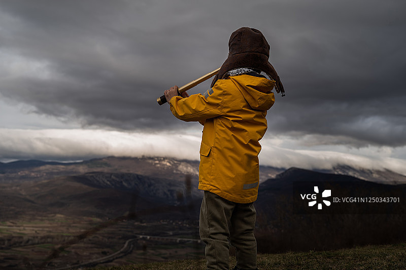 在自然中用双筒望远镜观察的男孩图片素材