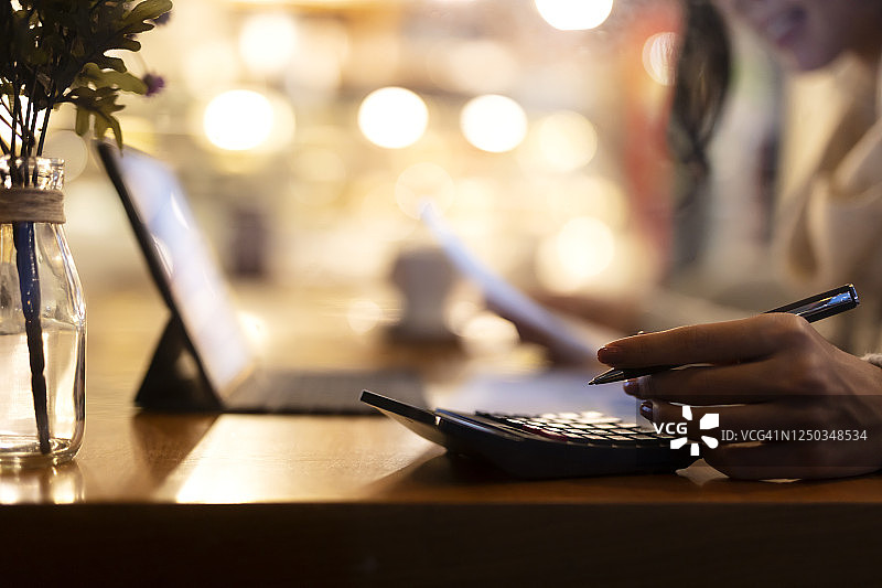 年轻女人在办公室使用计算器图片素材