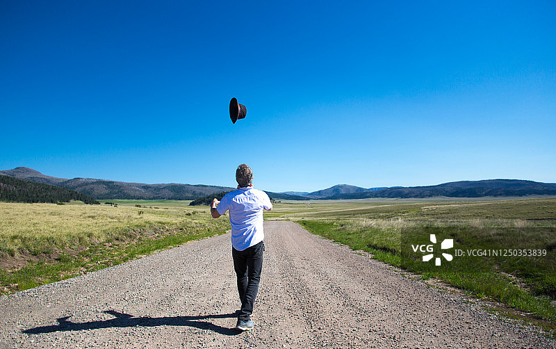 快乐的男人在新墨西哥州瓦列斯卡尔德拉荒野中扔帽子图片素材