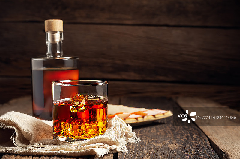 木桌上的威士忌酒杯和酒瓶特写图片素材