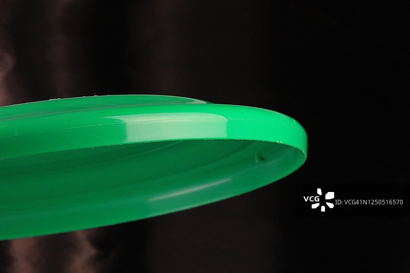 黑色背景上的玩具飞盘图片素材