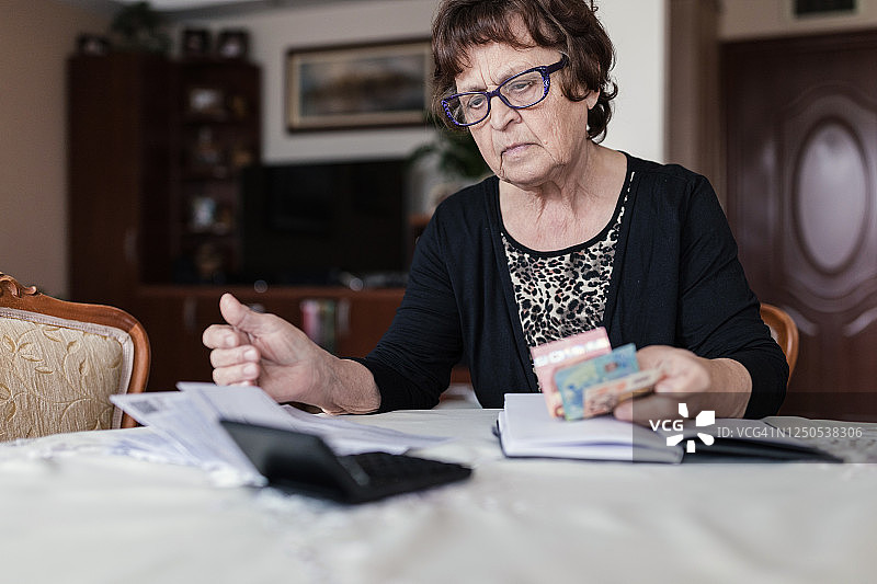 认真计算每月账单的老年妇女图片素材