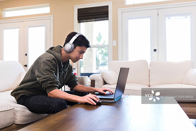 主播使用蓝牙耳机和笔记本电脑图片素材