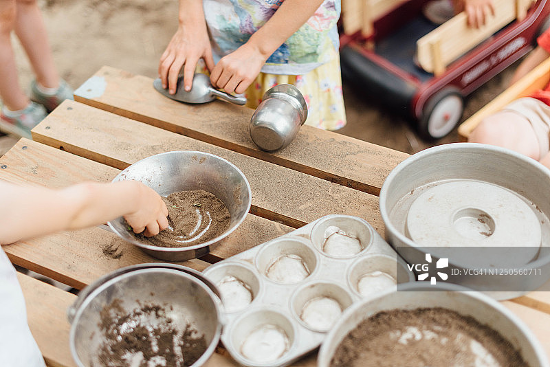 白人儿童用金属锅和平底锅玩沙子图片素材