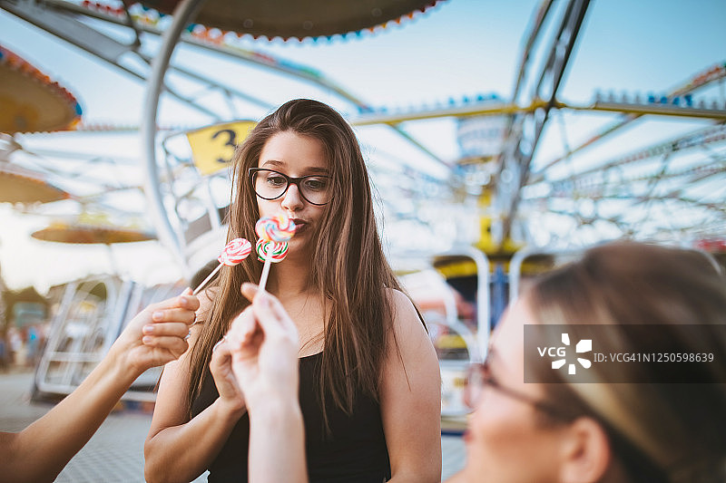 女孩们拿着棒棒糖玩闹图片素材