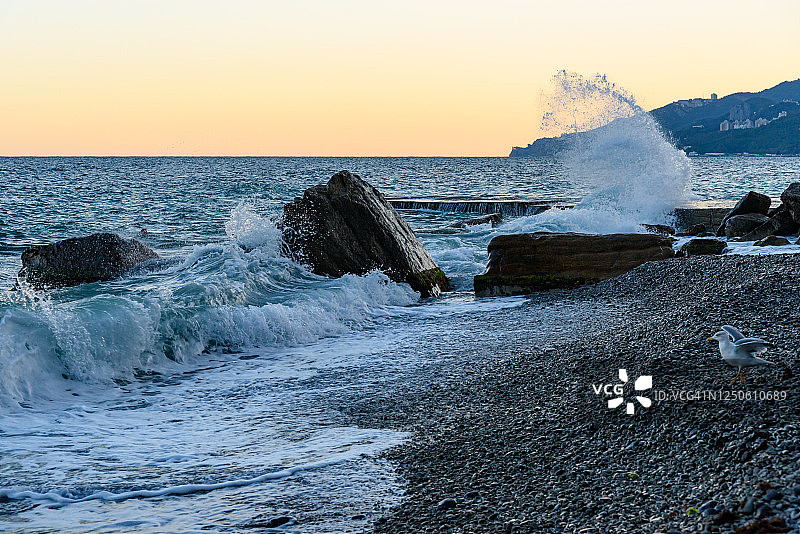 晴朗的亚尔塔市堤岸巨石上拍打的浪花图片素材