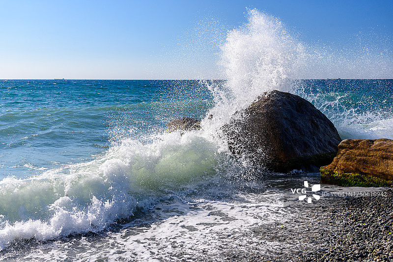 晴朗的亚尔塔市堤岸巨石上拍打的浪花图片素材