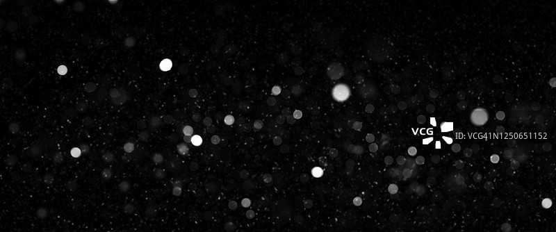 黑色背景上的散焦光和尘埃粒子图片素材