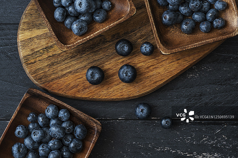 木碗中的新鲜蓝莓，木质背景，顶部视角，留白图片素材