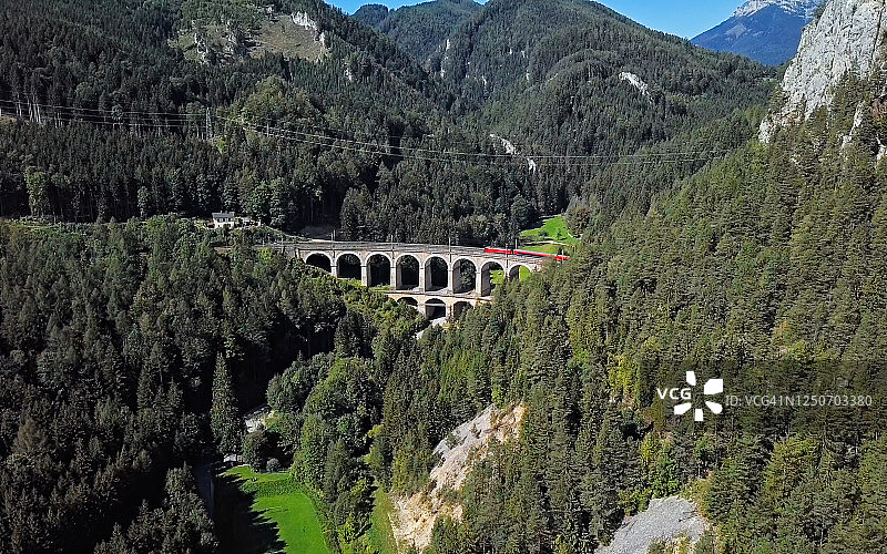 下奥地利州塞默灵铁路卡尔特林内高架桥上的红色火车航拍图片素材