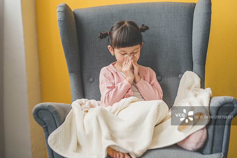 亚洲小女孩用纸巾擦鼻子图片素材