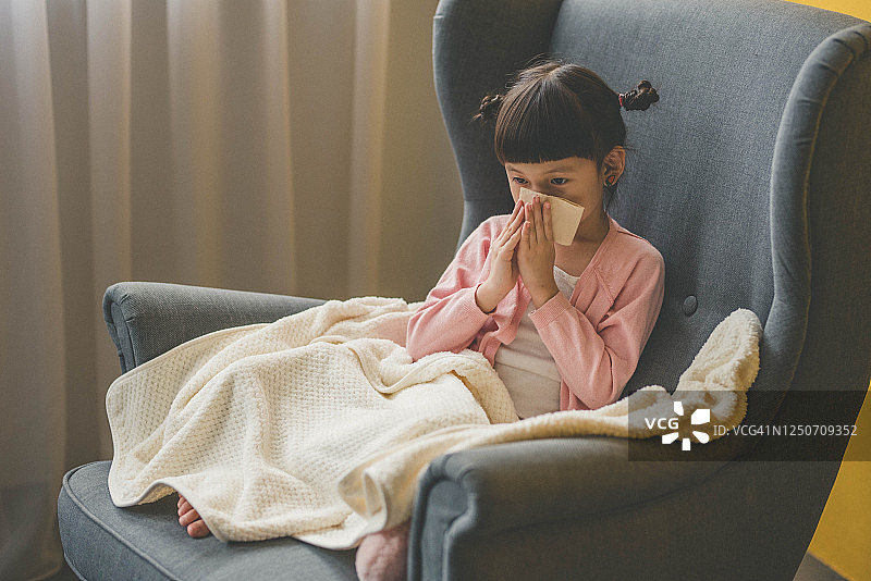 亚洲小女孩用纸巾擦鼻子图片素材