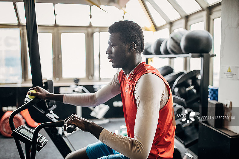 年轻的排球运动员在健身车上训练图片素材