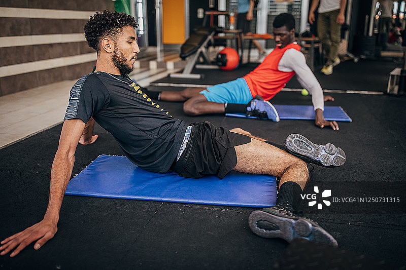 两名男子排球运动员在健身房伸展身体图片素材