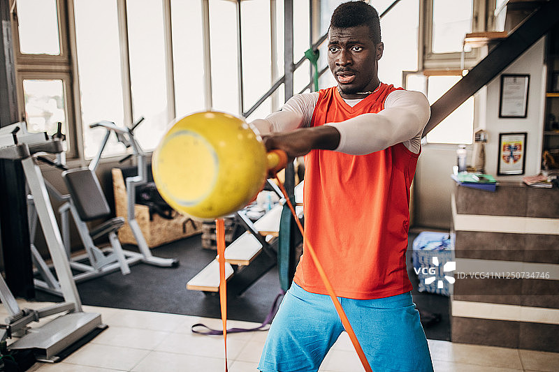 男人在健身房用壶铃训练排球图片素材
