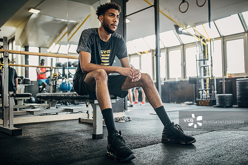 在健身房休息的男排球运动员图片素材