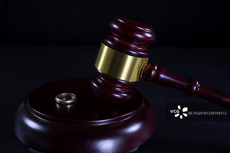 法庭离婚判决：法官的槌子和结婚戒指图片素材