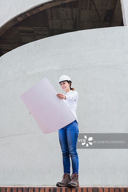戴安全帽的女工程师正在查看蓝图图片素材