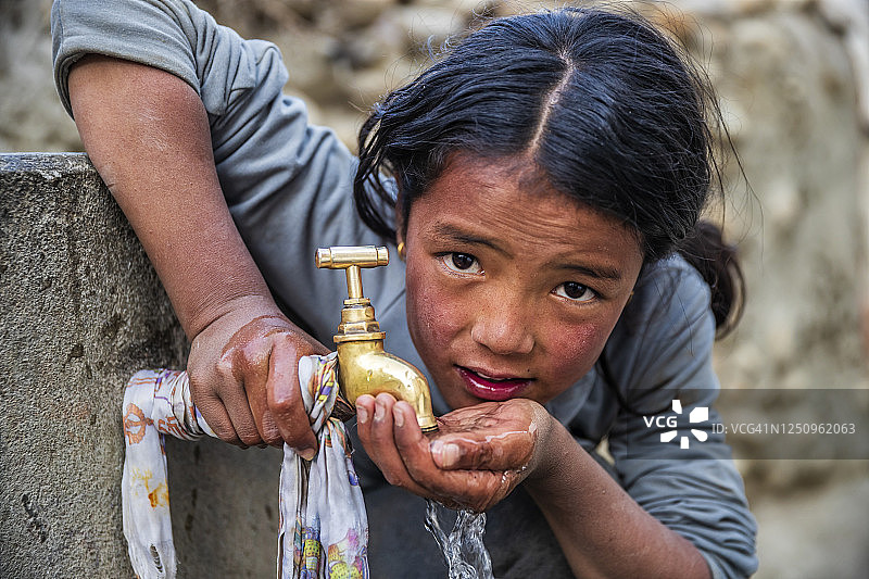 在尼泊尔上木斯塘喝水的尼泊尔女孩图片素材