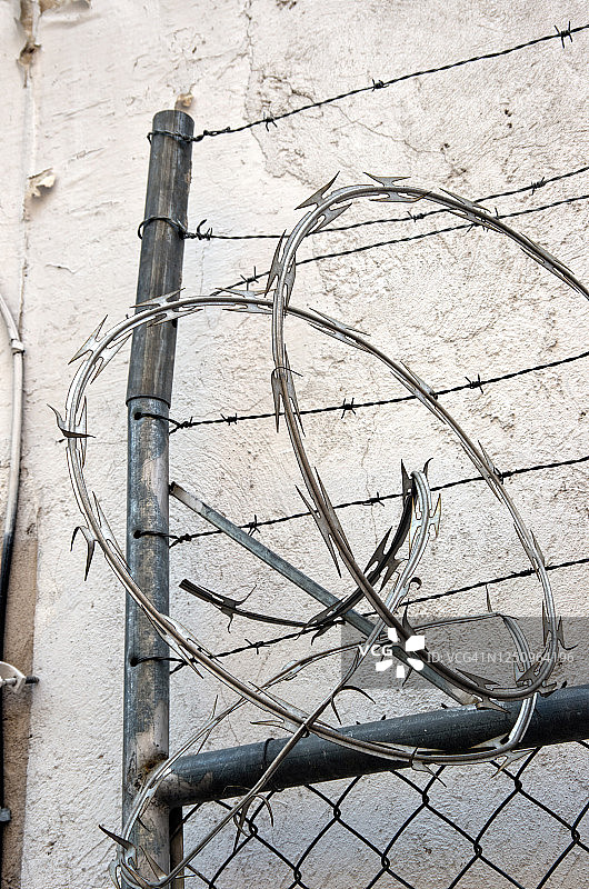 建筑物周围的金属丝网安全门顶部的刀片刺网和带刺铁丝网图片素材