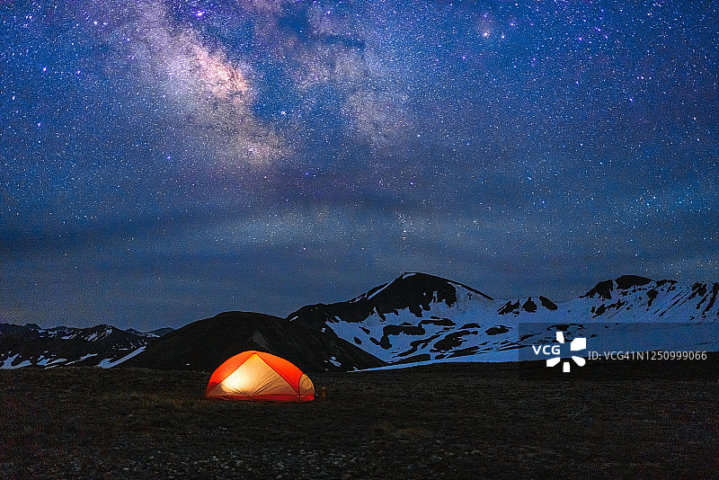 在夜空和银河下发光的背包帐篷图片素材