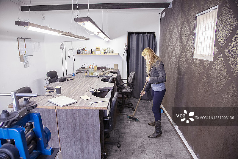 小企业主在她的工作室里打扫卫生图片素材