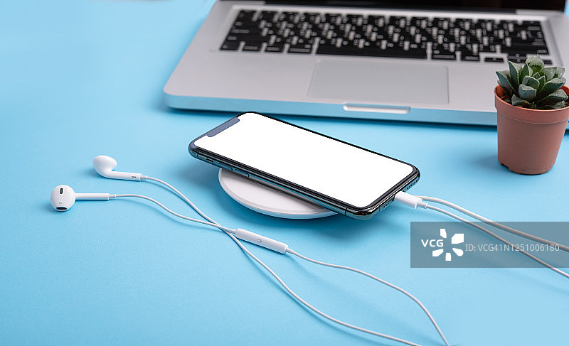 无线充电器上的智能手机空白屏幕俯视图图片素材