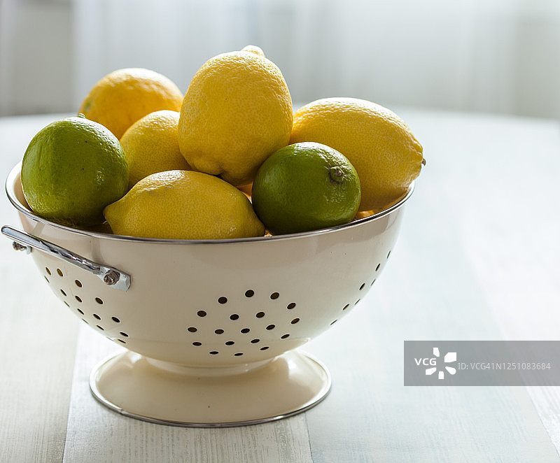 桌上的滤水器里的柠檬和青柠图片素材