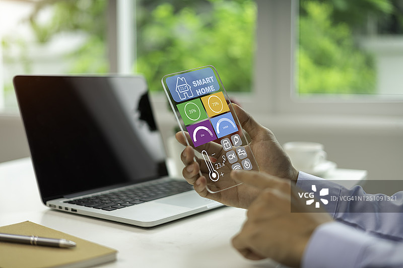 使用平板电脑和远程家庭控制系统智能家居技术界面的商人图片素材