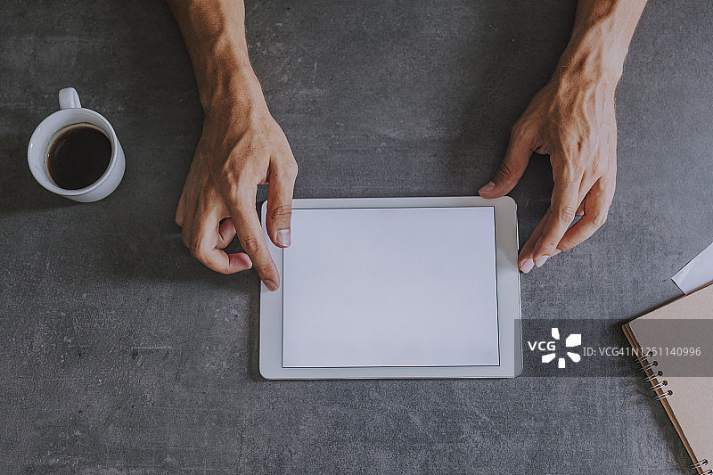 在家办公：使用空白屏幕平板电脑的男士图片素材